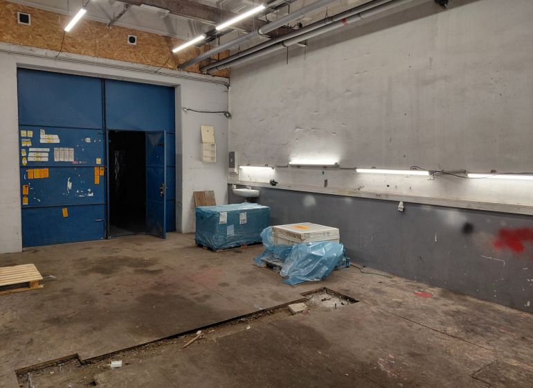 Lagerhallen und -gebäude mit blauen Türen, Beleuchtung und Materialien auf dem Boden mit Holzdekor.