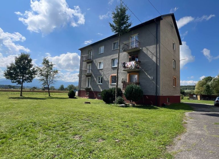 Ein Wohnhaus in Pribylina, umgeben von Grünflächen und blauem Himmel, mit Blick auf die umliegende Landschaft.