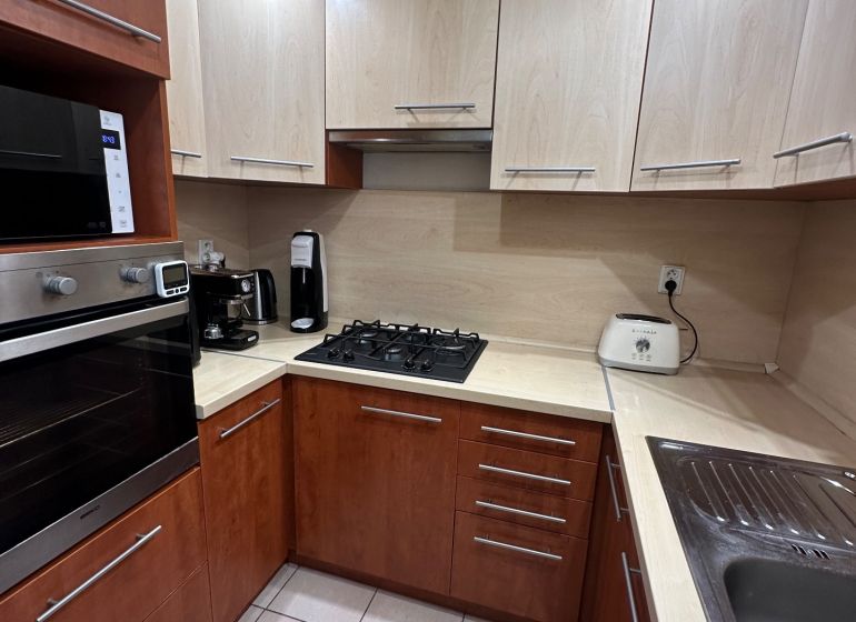 Küche mit Eckküche und Geräten in einer 3-Zimmer-Wohnung, Keramikfliesen.