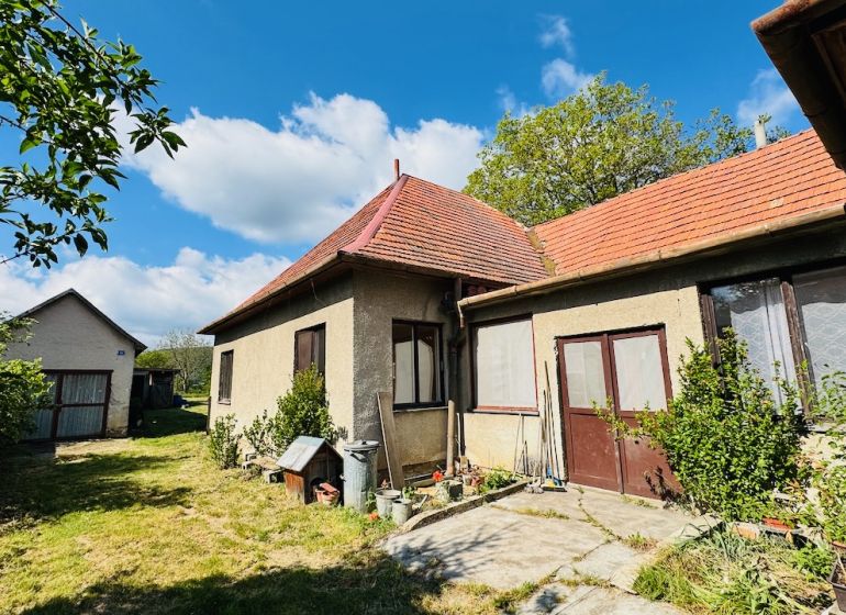 Ein Einfamilienhaus in Pažiti mit rotem Dach und Zugang zum Garten.