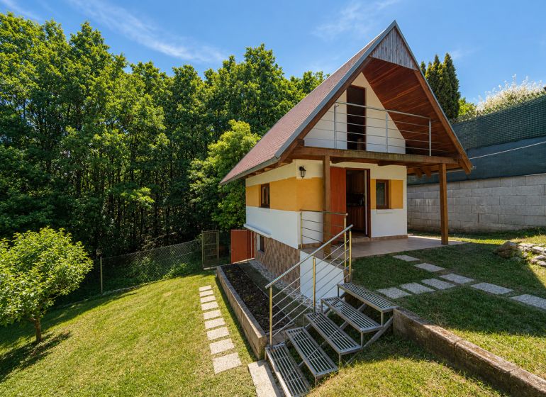 Eine Hütte mit Holzelementen in Považská Bystrica auf Klučina, umgeben von Grün und Bäumen.