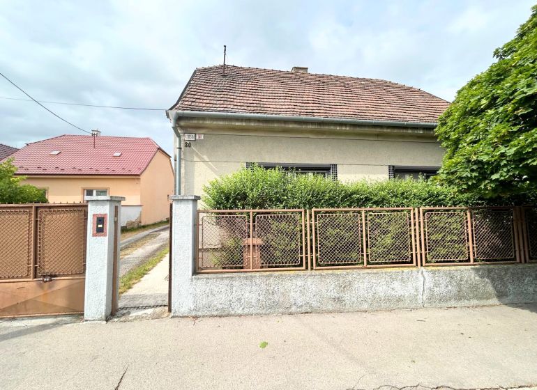 Ein Einfamilienhaus in der Krajinska-Straße in Bratislava - Podunajské Biskupice mit Zaun und Vorgarten.