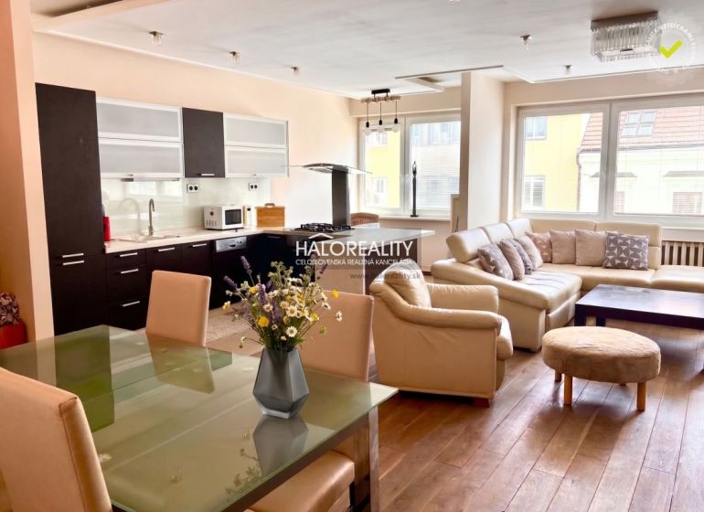 Küche mit weißen Möbeln, Ledersofa, Boden mit Holzdekor in einer 3-Zimmer-Wohnung.