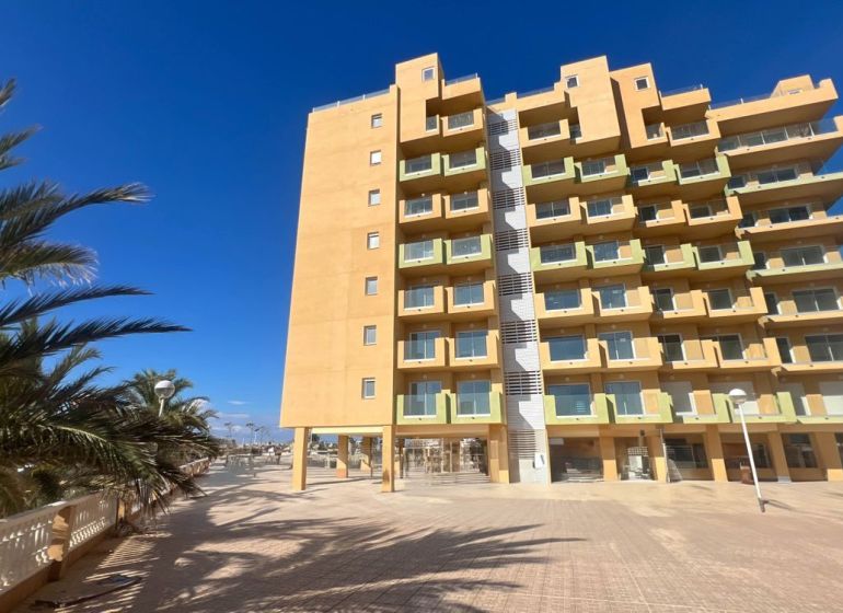 Ferienwohnung in La Manga del Mar Menor mit Palmen und klarem Himmel.
