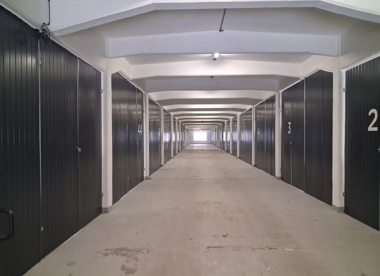 Langer Flur mit Garagenboxen in Lagern und Hallen.