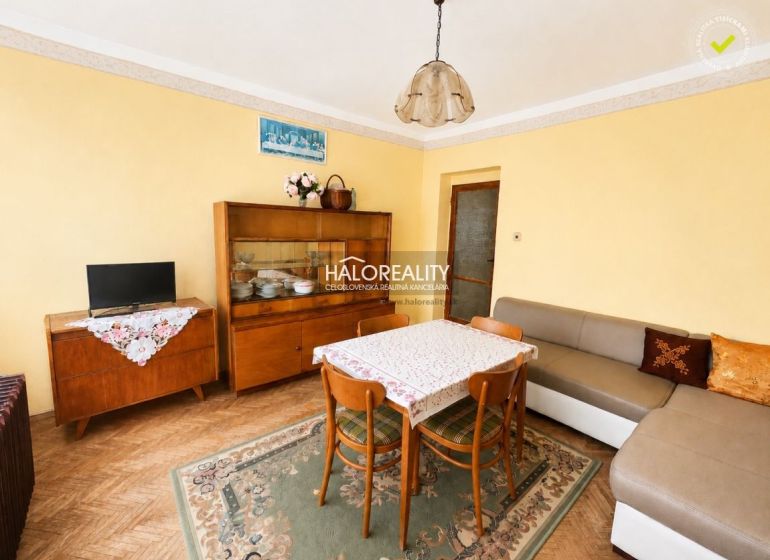Wohnzimmer in einem Einfamilienhaus mit Teppich und Möbeln, Boden mit Holzdekor.