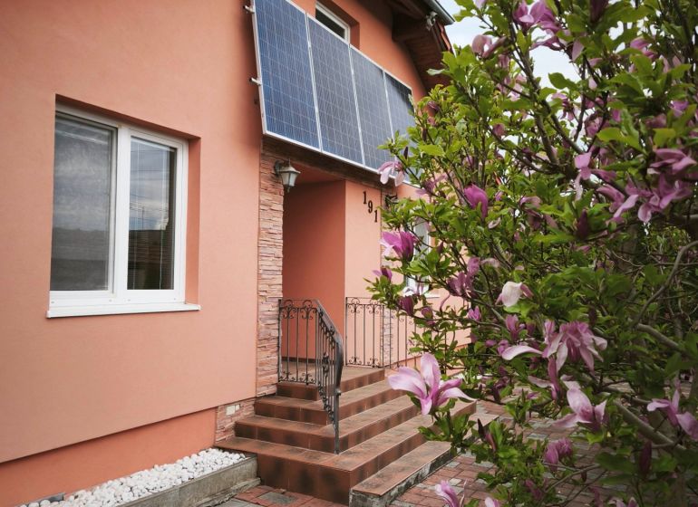 Ein Einfamilienhaus in der Hauptstraße in Martin nad Žitavou mit Solarpaneelen und einer Magnolie.