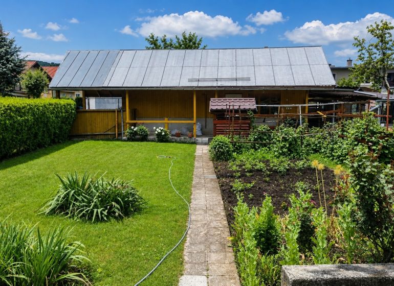 Ein Garten bei einem Einfamilienhaus in Slovenská Ľupča mit gepflegtem Rasen und kultivierten Pflanzen.