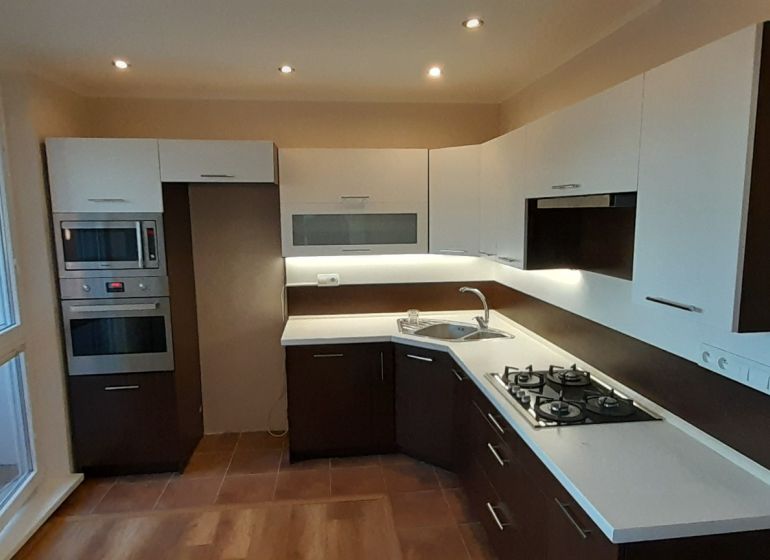 Küche in einer 2-Zimmer-Wohnung mit Holzboden und eingebauten Geräten.