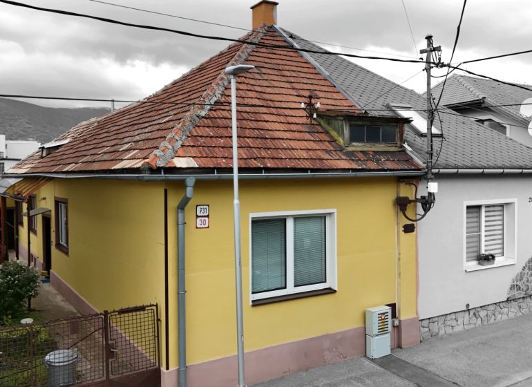 Ein Einfamilienhaus in Martin mit einem schrägen Dach und einer gelben Fassade.
