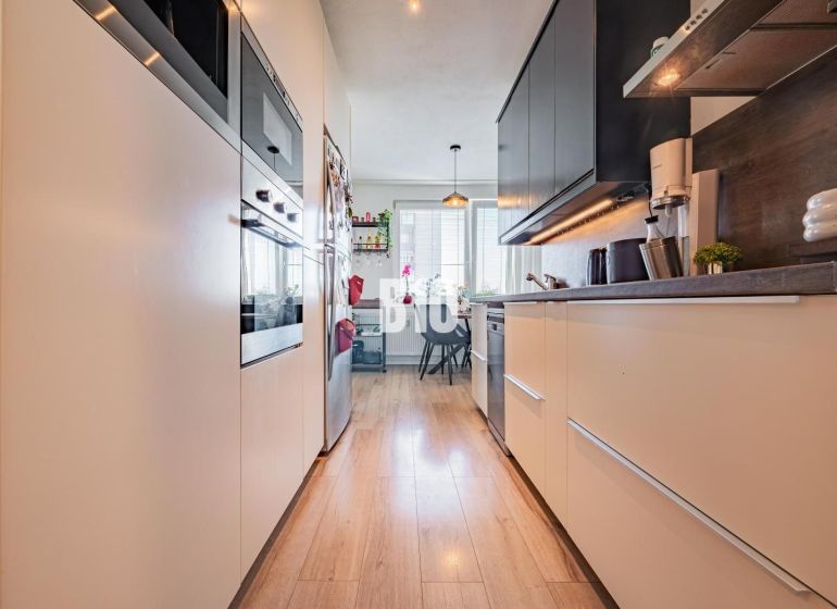 Küche in einer 3-Zimmer-Wohnung mit Holzboden und Geräten.