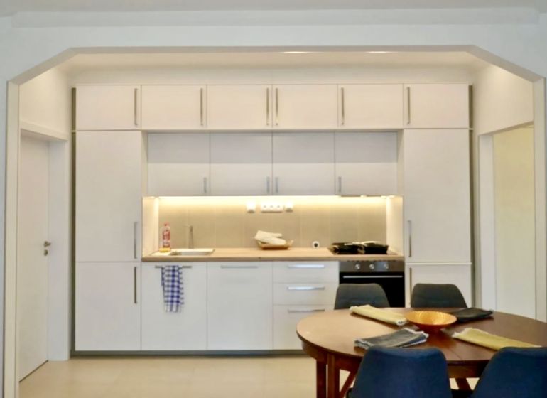 Küche in einer 3-Zimmer-Wohnung mit weißer Küchenzeile und Esstisch.