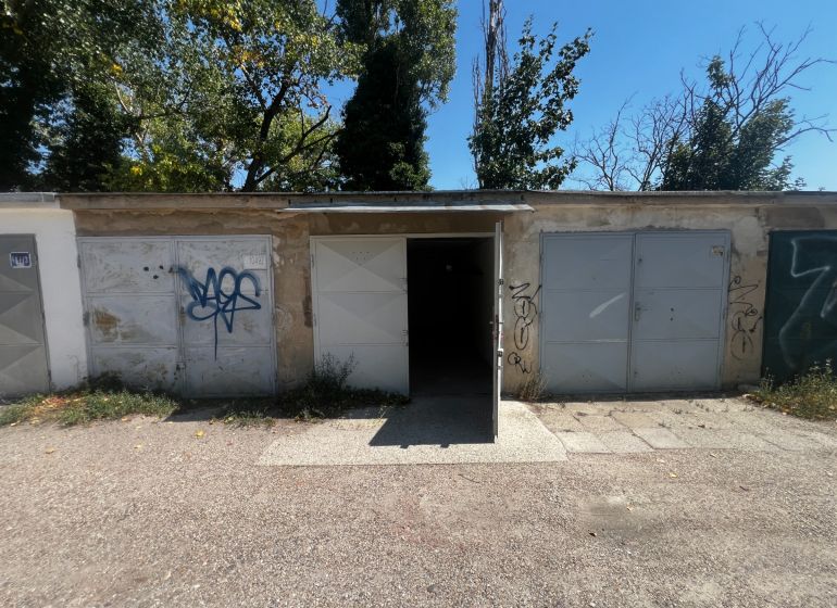 Offene Garagen an der Vyhnianska-Straße in Bratislava - Nové Mesto, umgeben von Bäumen.