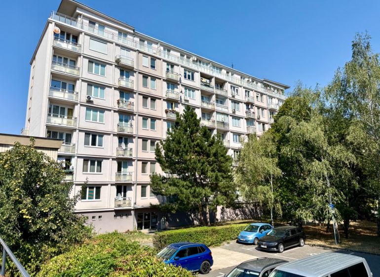 Mehrfamilienhaus in der Piešťanská Straße in Bratislava - Nové Mesto, umgeben von Grünflächen und einem Parkplatz.