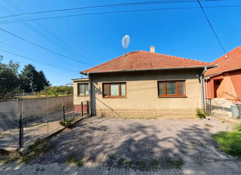 Ein Einfamilienhaus in der Školská-Straße in Tesárske Mlyňany mit einem gepflegten Hof und Zaun.