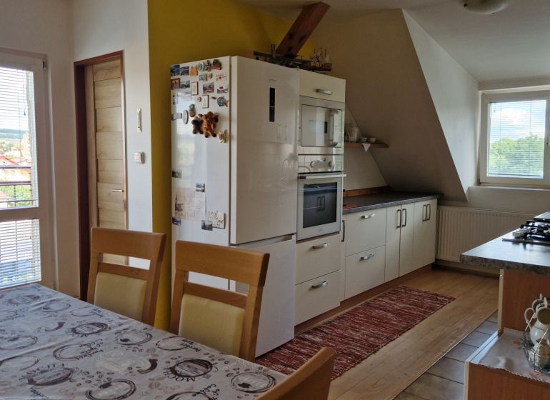 Küche in einer 2-Zimmer-Wohnung mit Holzboden und Esstisch.