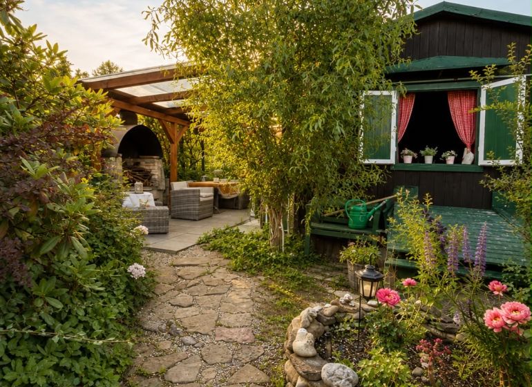 Der Garten bei der Hütte in Žilina mit steinernen Wegen und einem Blumenbeet.