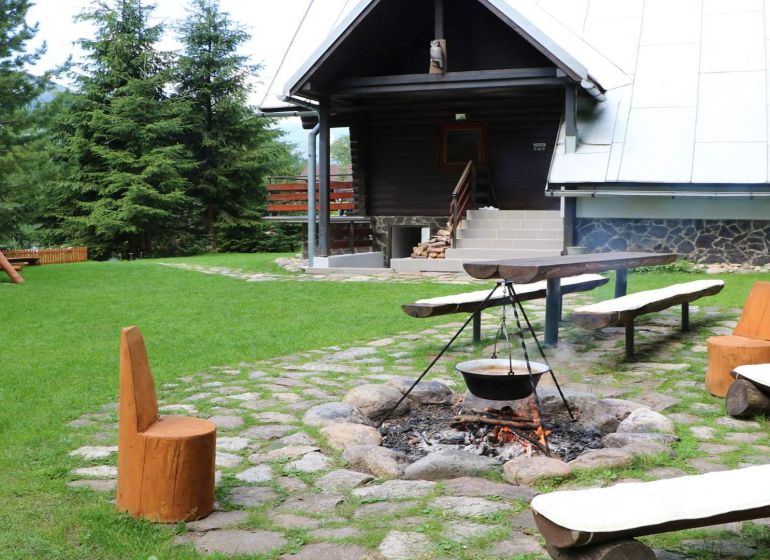 Blockhütte in Tále in Brezno mit Feuerstelle und Holzbänken im Rahmen von Hotels und Pensionen.