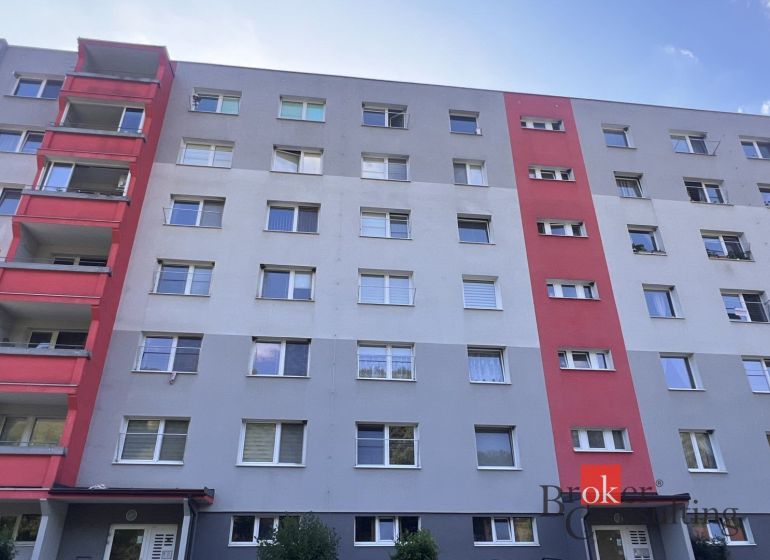 Ein sechsstöckiges Wohnhaus in Utekáč mit Balkonen und farbigen Teilen der Fassade.