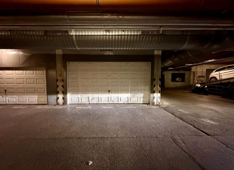 Innenraum von Garagen mit geschlossenen Toren und geparkten Fahrzeugen.