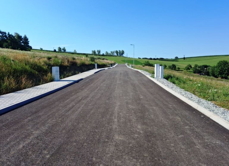 Ein leerer Weg zwischen grünen Feldern in Záborie, Grundstücke - Wohnen.