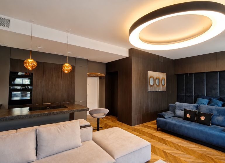 Wohnzimmer in einer 2-Zimmer-Wohnung mit Holzboden und interessanter Beleuchtung.