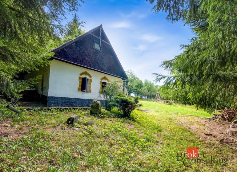 Eine Hütte in Píla, umgeben von Grün und Nadelbäumen, ideal zum Entspannen.