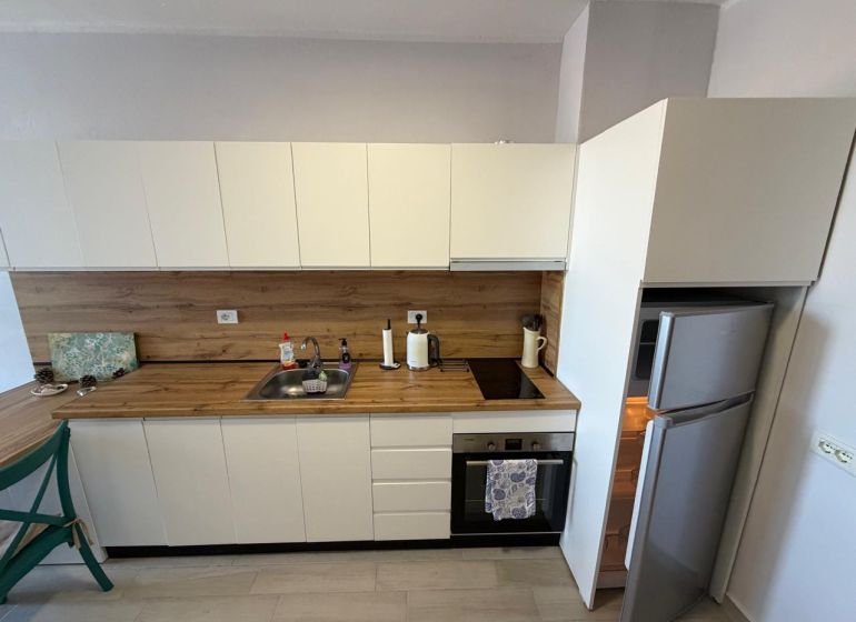 Küchenzeile mit Holzdekor und Ausstattung in einem Einzimmerapartment.