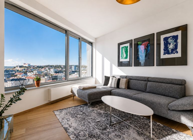 Wohnzimmer in einer 3-Zimmer-Wohnung mit Holzboden und Blick auf die Stadt.