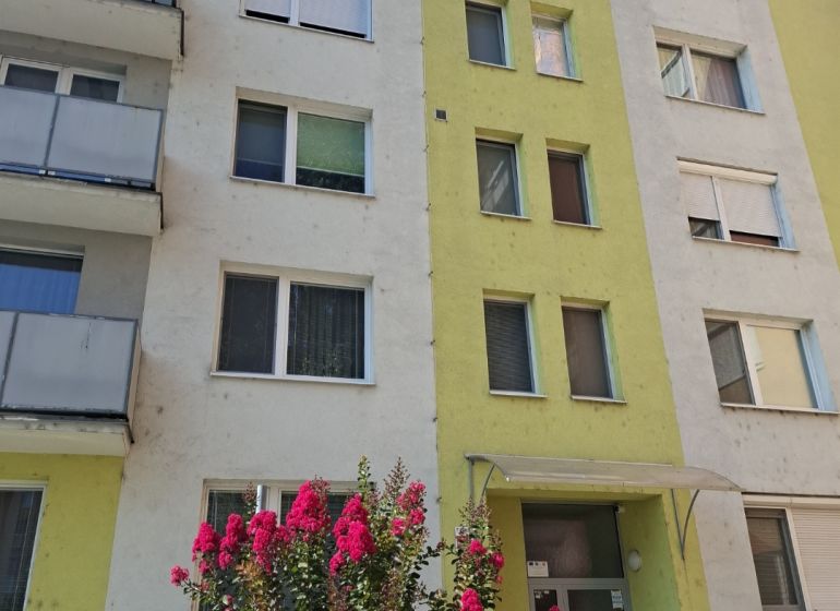 Wohnhaus an der SNP in Nové Zámky mit blühenden Sträuchern vor dem Eingang.