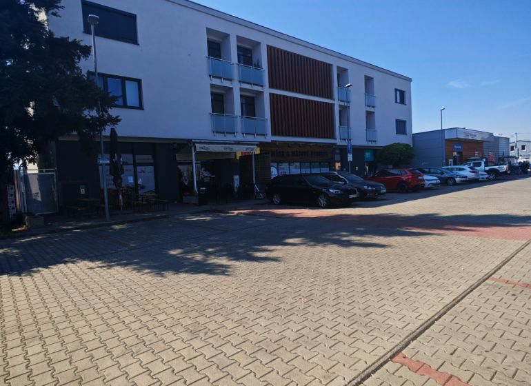 Das Gebäude in der Senická Straße in Rohožník mit Parkplätzen im Vordergrund.