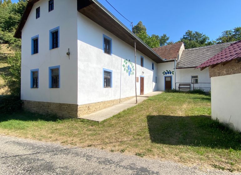 Ein Einfamilienhaus in Brestovec in der Straße Brestovec mit weißer Fassade und blauen Fenstern.