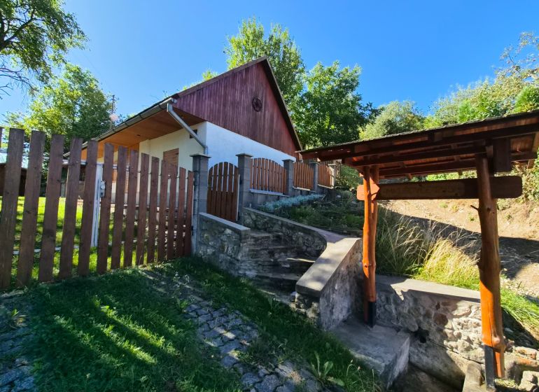 Ein Einfamilienhaus in Mikušovce mit einem Holzzaun und einer Steintreppe.