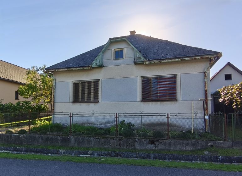 Ein Einfamilienhaus in der Komenského-Straße in Čebovce mit einer leicht vernachlässigten Fassade und einem Garten.