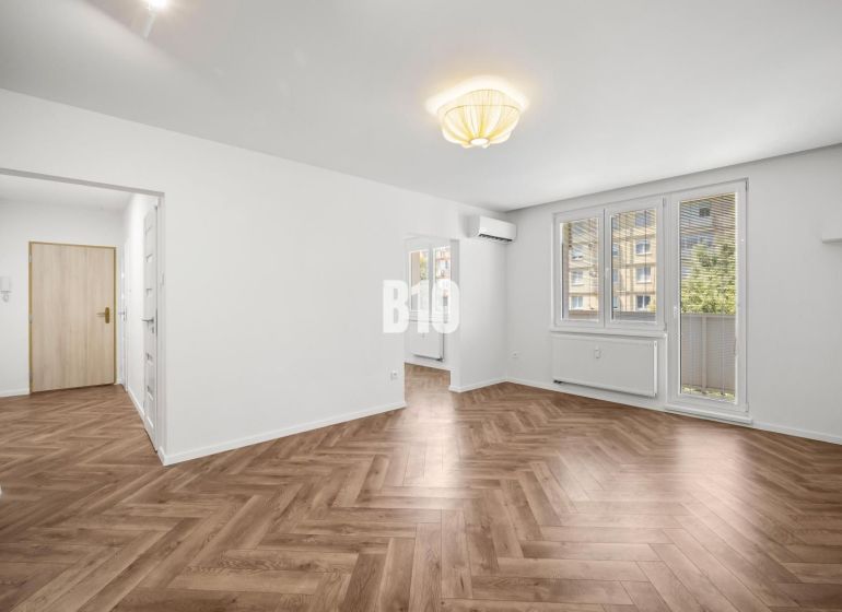 Wohnzimmer in einer 3-Zimmer-Wohnung mit gemustertem Boden in Holzoptik.