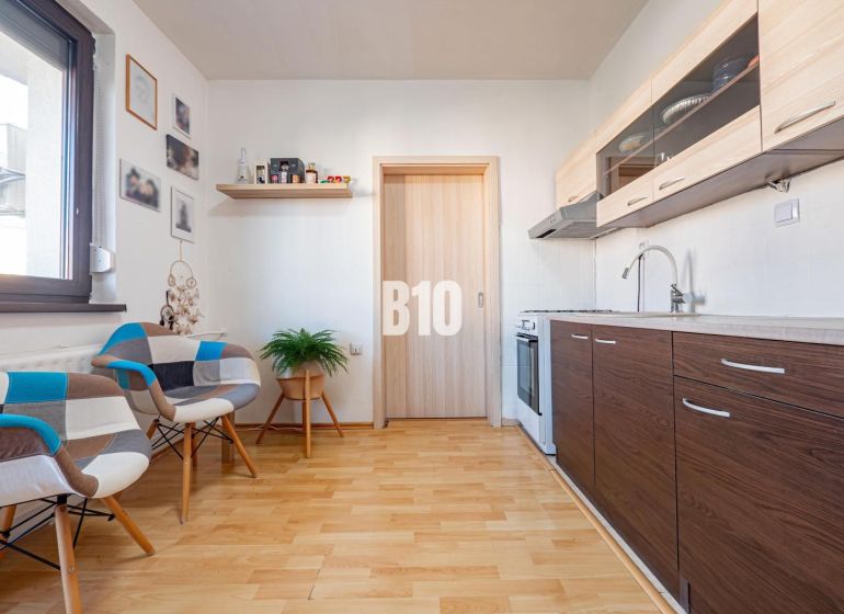 Die Küche in der Einzimmerwohnung mit einem Holzboden und modernen Möbeln.