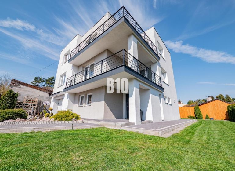 Ein Einfamilienhaus in Nitra mit einem großen grünen Garten und geräumigen Balkonen.