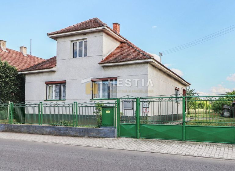 Ein Einfamilienhaus in Borský Mikuláš mit weißen Wänden und einem grünen Zaun.