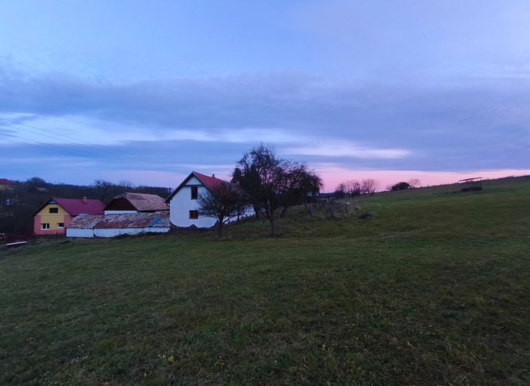 Ein Einfamilienhaus auf Prieloh in Dolná Strehová, umgeben von Natur bei Einbruch der Dämmerung.