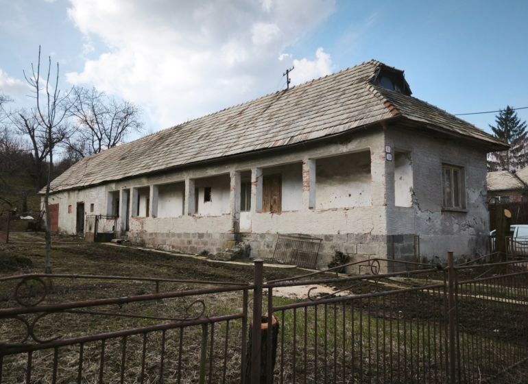 Ein Einfamilienhaus in der Tučekova-Straße in Veľký Krtíš mit einem alten Dach und einem Garten.