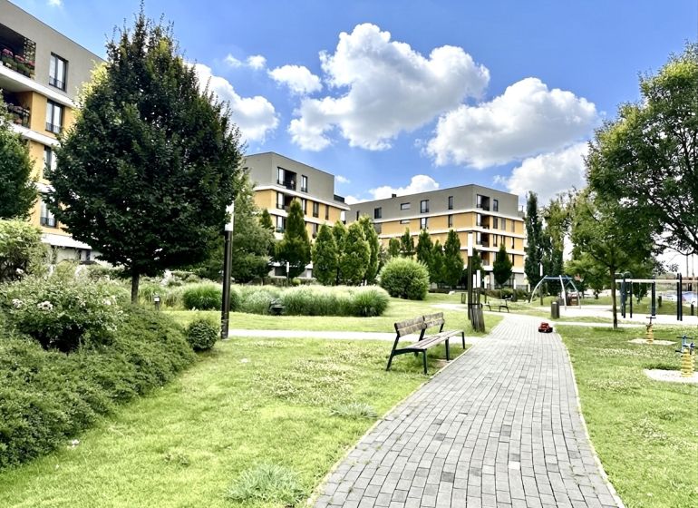 Wohnkomplex mit Park und Spielplatz an der Bajkalská in Bratislava, Ružinov, umgeben von Grünflächen.