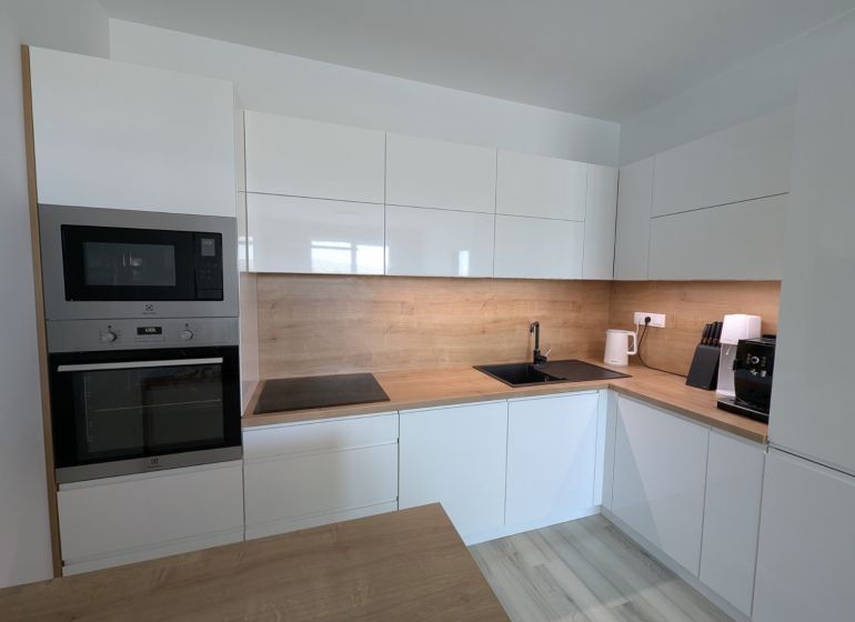 Küche in einer 2-Zimmer-Wohnung mit Holzboden und modernen Geräten.