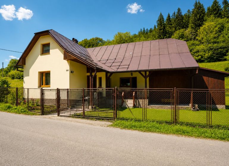 Ein Ferienhaus in der Straße Čierne in Makov mit einem Zier-Rasen und einem Holzzaun.