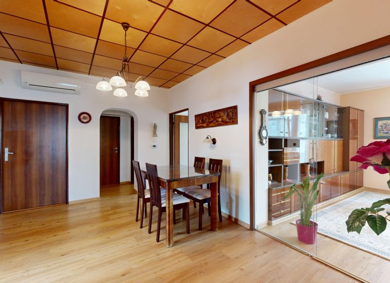 Esstisch und Stühle auf einem Boden mit Holzdekor in einer 3-Zimmer-Wohnung.