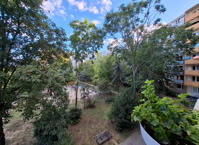 Blick vom Balkon einer 3-Zimmer-Wohnung in der Hospodárska-Straße in Trnava, mit Spielplatz und Bäumen.