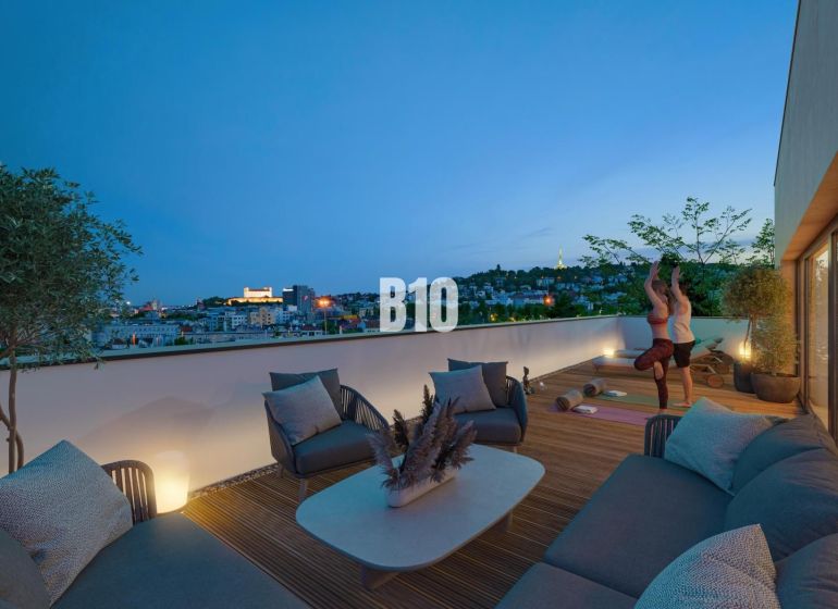 Eine Terrasse mit Blick auf die Stadt, bequeme Sitzgelegenheiten und ein Fitnessbereich in einer 3-Zimmer-Wohnung in Bratislava III, Pod Strážami.