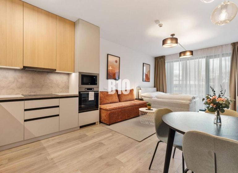 Küche und Wohnbereich einer Einzimmerwohnung mit Holzboden.