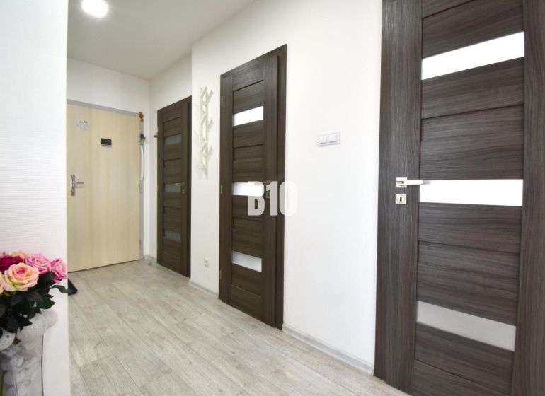 Flur mit Türen und Holzboden in einer 3-Zimmer-Wohnung.