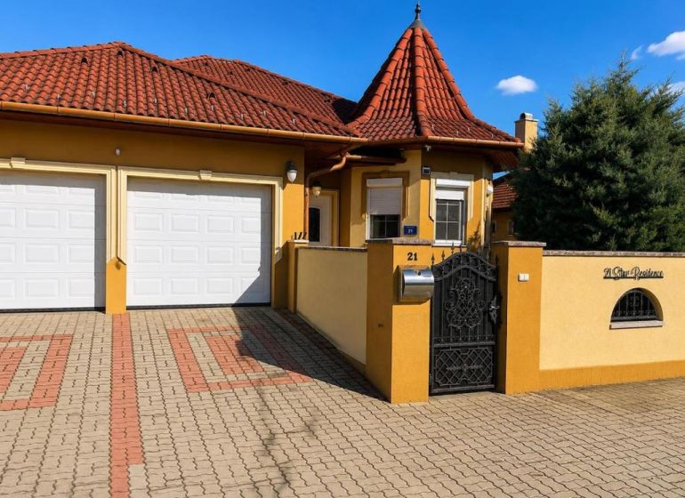 Ein Einfamilienhaus in Darnózseli mit einem Terrakotta-Dach und einer Doppelgarage.