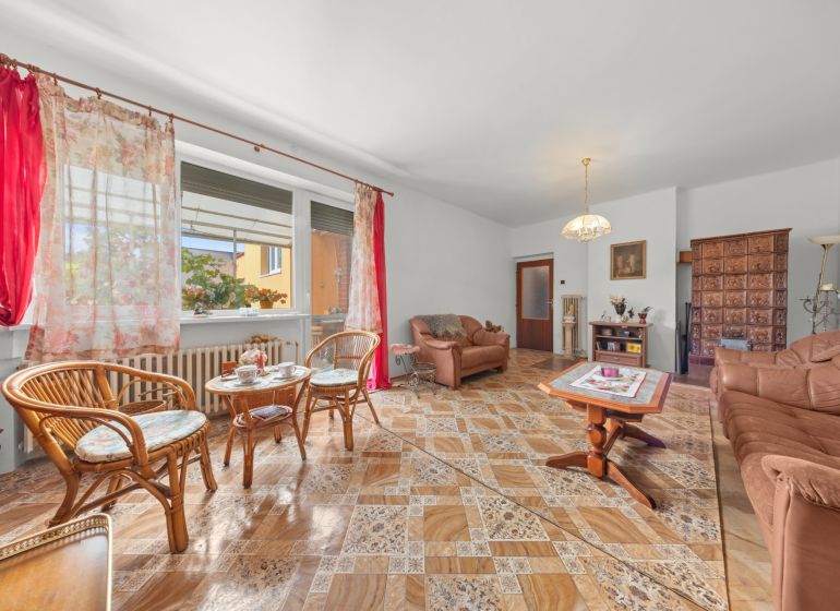 Wohnzimmer in einem Einfamilienhaus mit bequemen Möbeln und einem Boden in Holzoptik.